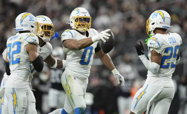 Los Angeles Chargers linebacker Daiyan Henley (0) celebrates with teammates after intercepting a pass against the Las Vegas Raiders during the first half of an NFL football game in Las Vegas, Sunday, Jan. 5, 2025. (AP Photo/John Locher)