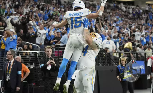 Los Angeles Chargers wide receiver Ladd McConkey (15) is congratulated by Scott Matlock (44) after scoring on a two point conversion during the first half of an NFL football game against the Las Vegas Raiders in Las Vegas, Sunday, Jan. 5, 2025. (AP Photo/John Locher)