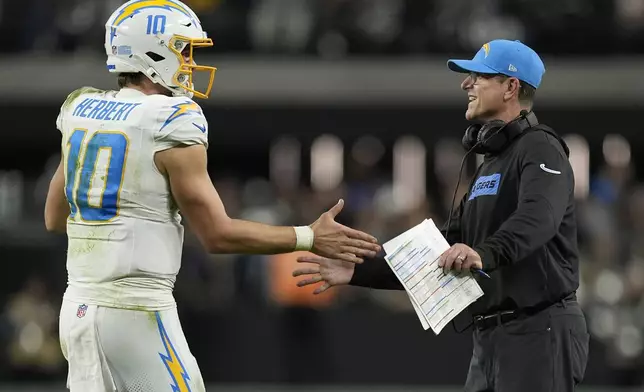 Los Angeles Chargers quarterback Justin Herbert (10) celebrates with head coach Jim Harbaugh during the second half of an NFL football game against the Las Vegas Raiders in Las Vegas, Sunday, Jan. 5, 2025. (AP Photo/John Locher)