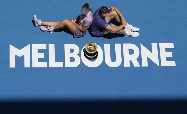 Olivia Gadecki and John Peers of Australia hold their trophy aloft after defeating compatriots Kimberly Birrell and John-Patrick Smith in the mixed doubles final at the Australian Open tennis championship in Melbourne, Australia, Friday, Jan. 24, 2025.(AP Photo/Manish Swarup)