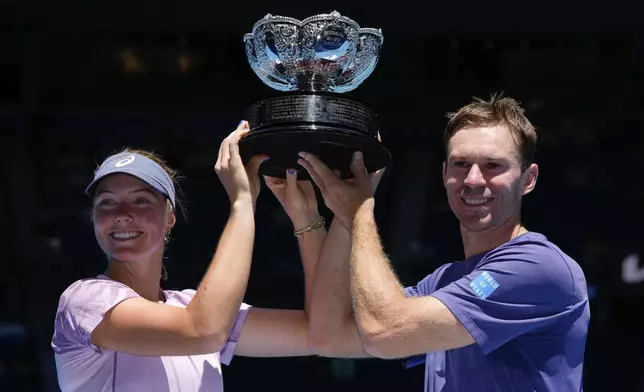 Olivia Gadecki and John Peers of Australia hold their trophy aloft after defeating compatriots Kimberly Birrell and John-Patrick Smith in the mixed doubles final at the Australian Open tennis championship in Melbourne, Australia, Friday, Jan. 24, 2025.(AP Photo/Asanka Brendon Ratnayake)