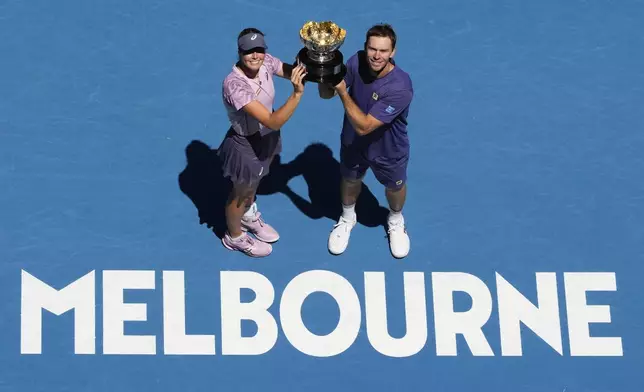 Olivia Gadecki and John Peers of Australia hold their trophy aloft after defeating compatriots Kimberly Birrell and John-Patrick Smith in the mixed doubles final at the Australian Open tennis championship in Melbourne, Australia, Friday, Jan. 24, 2025.(AP Photo/Manish Swarup)