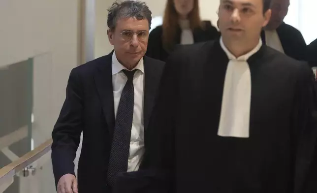 Alexandre Djouhri, left, a French-Algerian businessman, arrives to the courtroom as former French President Nicolas Sarkozy goes on trial over alleged illegal financing of his 2007 presidential campaign by the government of late Libyan leader Moammar Gadhafi, Monday, Jan. 6, 2025 in Paris. (AP Photo/Thibault Camus)