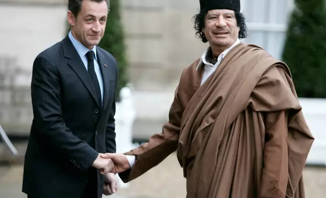 FILE - French President Nicolas Sarkozy, left, greets Libyan leader Col. Moammar Gadhafi upon his arrival at the Elysee Palace, Dec. 10 2007 in Paris. France's former President Nicolas Sarkozy goes on trial Monday Jan.6, 2025 over alleged illegal financing of his 2007 presidential campaign by the government of late Libyan leader Moammar Gadhafi. (AP Photo/Francois Mori, File)