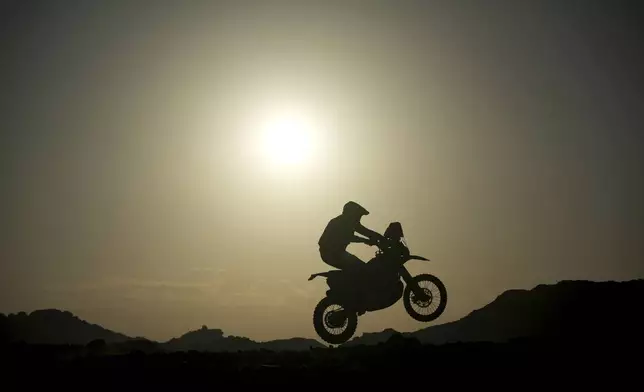 A rider jumps during the sixth stage of the Dakar Rally between Hail and Al Duwadimi, Saudi Arabia, Saturday, Jan. 11, 2025. (AP Photo/Christophe Ena)