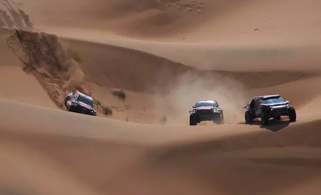 From left, Driver Seth Quintero and co-driver Dennis Zenz , Driver Yazeed Al Rajhi and co-driver Timo Gottschalk, Driver Nasser Al-Attiya, and co-driver Edouard Boulanger compete during the eighth stage of the Dakar Rally between Al Duwadimi and Riyadh, Saudi Arabia, Monday, Jan. 13, 2025. (AP Photo/Christophe Ena)