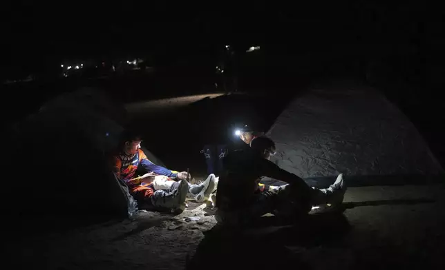 Riders have dinner at the bivouac after the stage two, day one, of the Dakar Rally with start in Bisha and finish in Bisha, Saudi Arabia, Sunday, Jan. 5, 2025. (AP Photo/Christophe Ena)