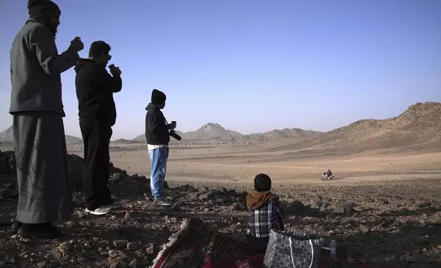 People watch the riders during the prologue of the Dakar Rally in Bisha, Saudi Arabia, Friday, Jan. 3, 2025. (AP Photo/Christophe Ena)