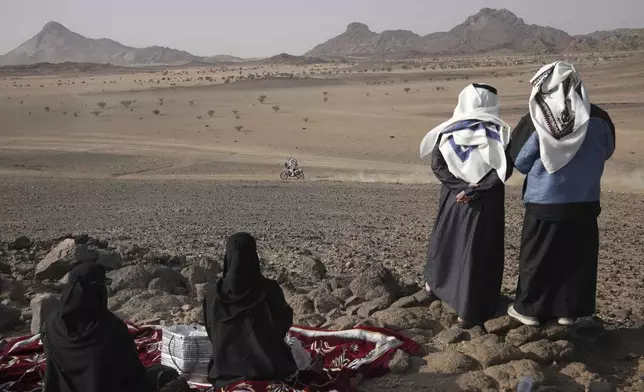 Local people watch the riders during the prologue of the Dakar Rally in Bisha, Saudi Arabia, Friday, Jan. 3, 2025. (AP Photo/Christophe Ena)