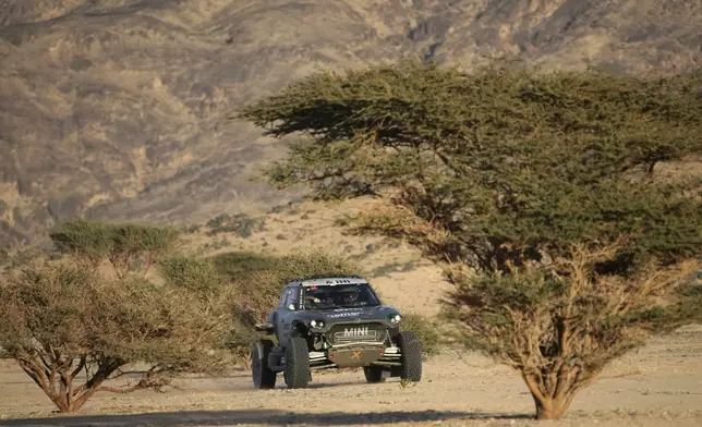 X-Raid Mini driver Guerlain Chicherit and co-pilot Alexandre Winocq, both of France, arrive at the bivouac after the stage two, day one, of the Dakar Rally with start in Bisha and finish in Bisha, Saudi Arabia, Sunday, Jan. 5, 2025. (AP Photo/Christophe Ena)