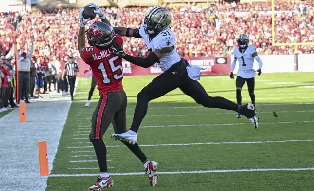 Tampa Bay Buccaneers wide receiver Jalen McMillan (15) pulls in a touchdown reception against New Orleans Saints safety Jordan Howden (31) during the second half of an NFL football game Sunday, Jan. 5, 2025, in Tampa, Fla. (AP Photo/Jason Behnken)