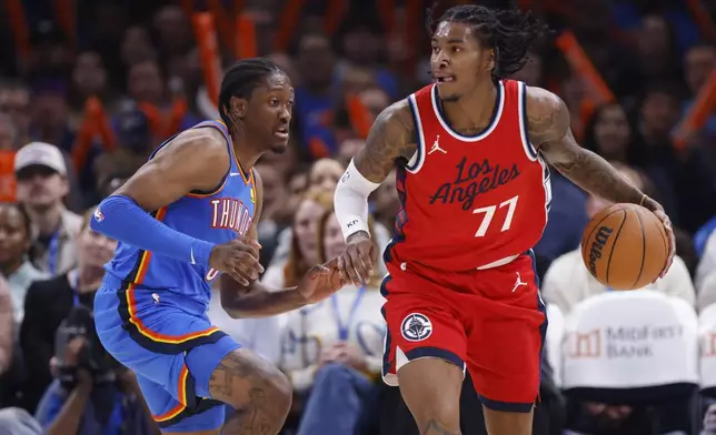 Los Angeles Clippers guard Kevin Porter Jr. (77) drives against Oklahoma City Thunder forward Jalen Williams, left, during the first half of an NBA basketball game Thursday, Jan. 2, 2025, in Oklahoma City. (AP Photo/Nate Billings)