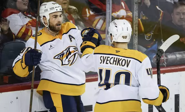 Nashville Predators' Ryan O'Reilly, left, celebrates his goal with teammate Fedor Svechkov during the second period of an NHL hockey game against the Calgary Flames in Calgary, Alberta, Saturday, Jan. 4, 2025. (Jeff McIntosh/The Canadian Press via AP)