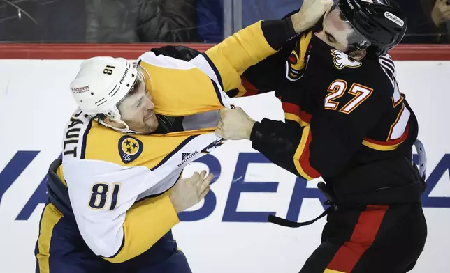 Nashville Predators' Jonathan Marchessault, left, fights with Calgary Flames' Matthew Coronato during the third period of an NHL hockey game in Calgary, Alberta, Saturday, Jan. 4, 2025. (Jeff McIntosh/The Canadian Press via AP)