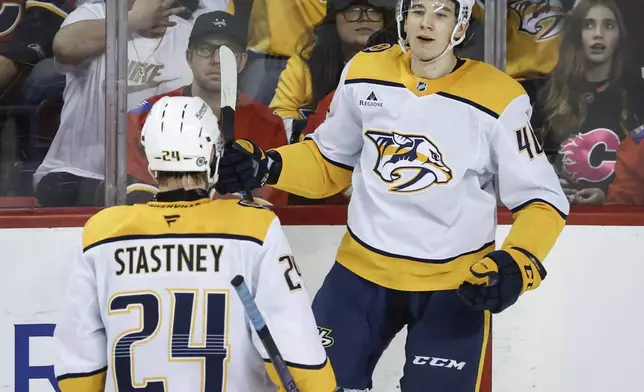 Nashville Predators' Fedor Svechkov, right, celebrates his goal with teammate Spencer Stastney during the third period of an NHL hockey game against the Calgary Flames in Calgary, Alberta, Saturday, Jan. 4, 2025. (Jeff McIntosh/The Canadian Press via AP)