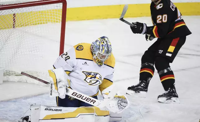 Nashville Predators goalie Justus Annunen, left, stops a shot from Calgary Flames' Blake Coleman during the first period of an NHL hockey game in Calgary, Alberta, Saturday, Jan. 4, 2025. (Jeff McIntosh/The Canadian Press via AP)