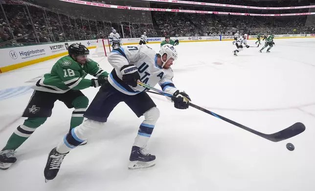 Utah Hockey Club left wing Lawson Crouse (67) clears the puck away as Dallas Stars center Sam Steel (18) challenges him during the first period of an NHL hockey game, Saturday, Jan. 4, 2025, in Dallas. (AP Photo/Julio Cortez)