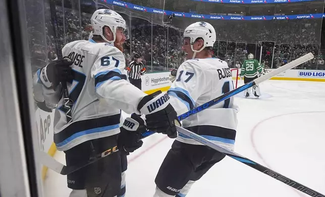 Utah Hockey Club left wing Lawson Crouse (67) and defenseman Michael Kesselring (7) celebrate after left wing Matias Maccelli, not visible, scored his first of two second period goals during an NHL hockey game against the Dallas Stars, Saturday, Jan. 4, 2025, in Dallas. (AP Photo/Julio Cortez)