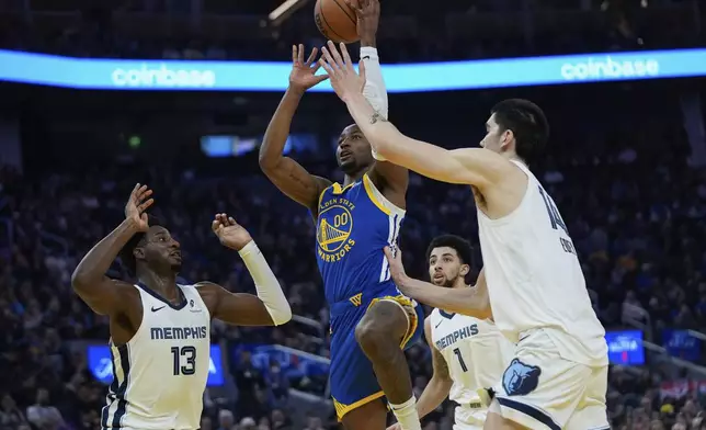 Golden State Warriors forward Jonathan Kuminga, center, looks to shoot between Memphis Grizzlies forward Jaren Jackson Jr., left, and center Zach Edey, right, during the first half of an NBA basketball game Saturday, Jan. 4, 2025, in San Francisco. (AP Photo/Godofredo A. Vásquez)