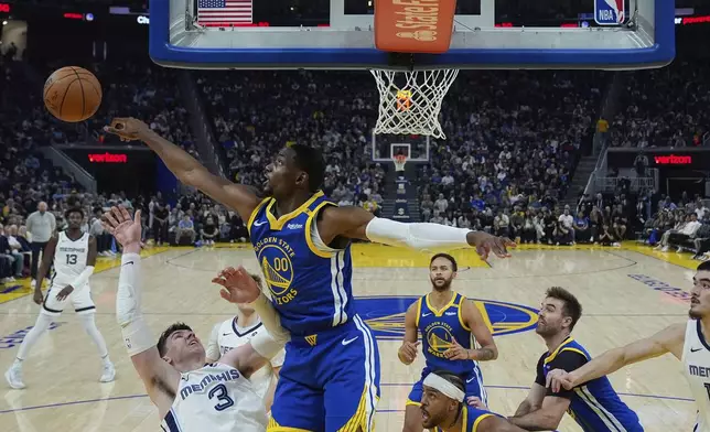 Golden State Warriors forward Jonathan Kuminga (00) blocks a shot by Memphis Grizzlies forward Jake LaRavia (3) during the first half of an NBA basketball game Saturday, Jan. 4, 2025, in San Francisco. (AP Photo/Godofredo A. Vásquez)