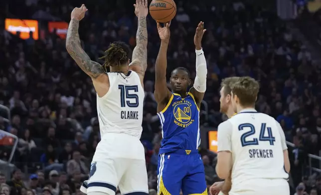 Golden State Warriors forward Jonathan Kuminga, center, shoots a 3-point basket over Memphis Grizzlies forward Brandon Clarke, left, during the first half of an NBA basketball game Saturday, Jan. 4, 2025, in San Francisco. (AP Photo/Godofredo A. Vásquez)