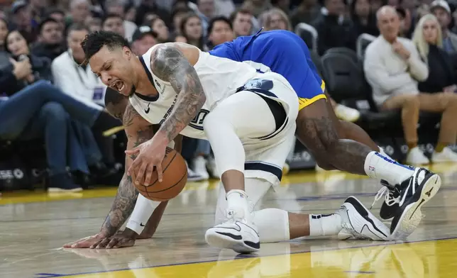 Memphis Grizzlies forward Brandon Clarke, front, recovers the ball next to Golden State Warriors forward Jonathan Kuminga, back, during the first half of an NBA basketball game Saturday, Jan. 4, 2025, in San Francisco. (AP Photo/Godofredo A. Vásquez)