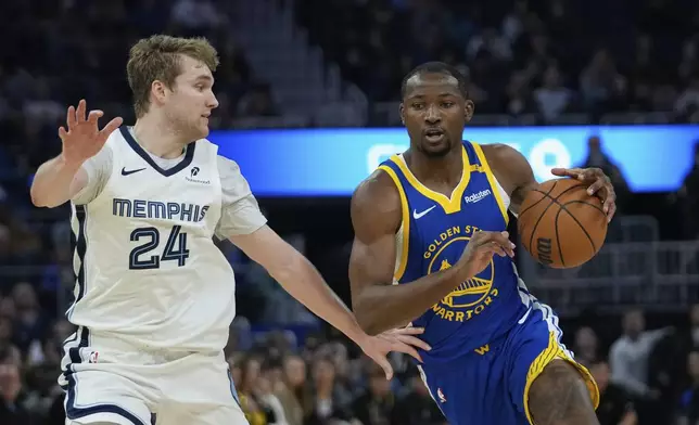 Golden State Warriors forward Jonathan Kuminga, right, moves the ball while defended by Memphis Grizzlies guard Cam Spencer during the first half of an NBA basketball game Saturday, Jan. 4, 2025, in San Francisco. (AP Photo/Godofredo A. Vásquez)