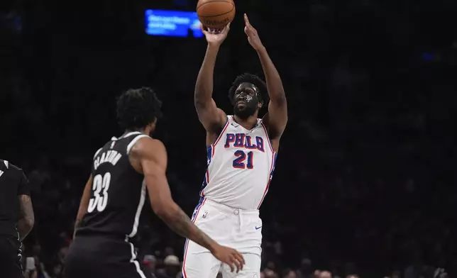 Philadelphia 76ers' Joel Embiid (21) shoots over Brooklyn Nets' Nic Claxton (33) during the second half of an NBA basketball game Saturday, Jan. 4, 2025, in New York. (AP Photo/Frank Franklin II)