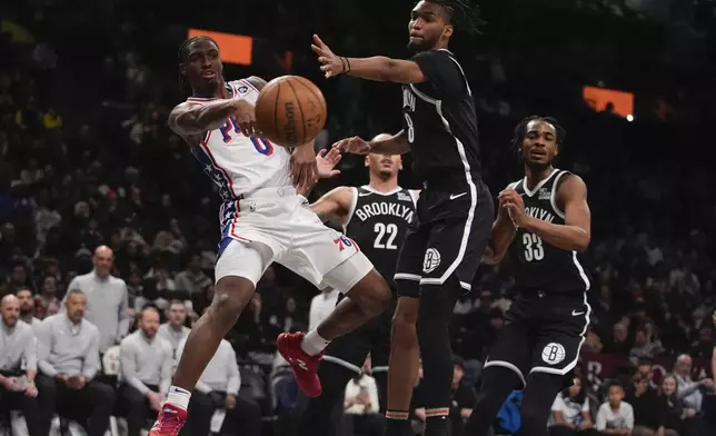 Philadelphia 76ers' Tyrese Maxey (0) passes the ball away from Brooklyn Nets' De'Anthony Melton (8) during the second half of an NBA basketball game Saturday, Jan. 4, 2025, in New York. (AP Photo/Frank Franklin II)