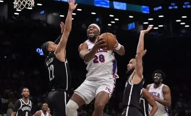 Philadelphia 76ers' Guerschon Yabusele (28) drives past Brooklyn Nets' Jalen Wilson (22) and Tyrese Martin during the second half of an NBA basketball game Saturday, Jan. 4, 2025, in New York. (AP Photo/Frank Franklin II)