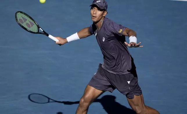 Kasidit Samrej of Thailand plays a forehand return to Daniil Medvedev of Russia during their first round match at the Australian Open tennis championship in Melbourne, Australia, Tuesday, Jan. 14, 2025. (AP Photo/Ng Han Guan)