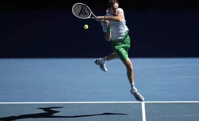Daniil Medvedev of Russia plays a backhand return to Kasidit Samrej of Thailand during their first round match at the Australian Open tennis championship in Melbourne, Australia, Tuesday, Jan. 14, 2025. (AP Photo/Ng Han Guan)