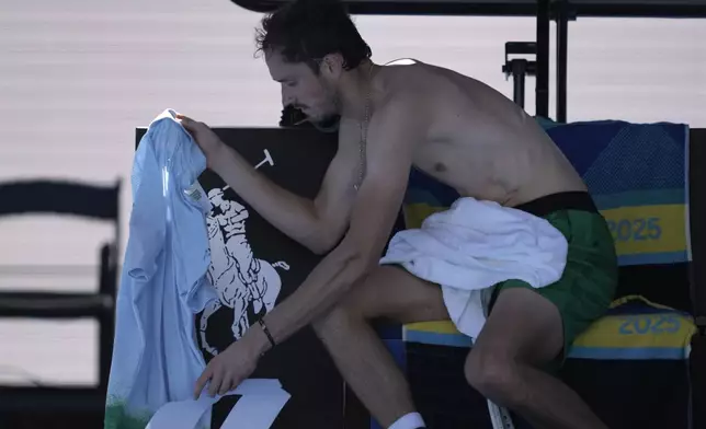 Daniil Medvedev of Russia changes his shirt during his first round match against Kasidit Samrej of Thailand at the Australian Open tennis championship in Melbourne, Australia, Tuesday, Jan. 14, 2025. (AP Photo/Ng Han Guan)