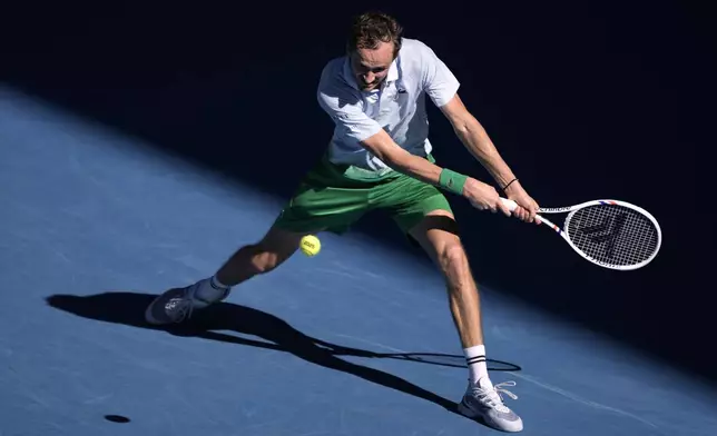 Daniil Medvedev of Russia plays a backhand return to Kasidit Samrej of Thailand during their first round match at the Australian Open tennis championship in Melbourne, Australia, Tuesday, Jan. 14, 2025. (AP Photo/Ng Han Guan)