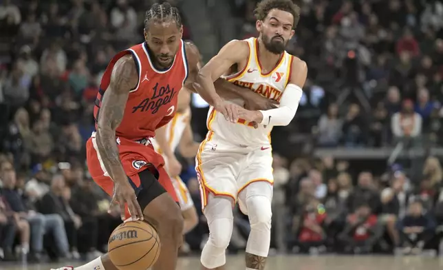 Los Angeles Clippers forward Kawhi Leonard, left, steals the ball from Atlanta Hawks guard Trae Young during the first half of an NBA basketball game Saturday, Jan. 4, 2025, in Los Angeles. (AP Photo/Jayne-Kamin-Oncea)