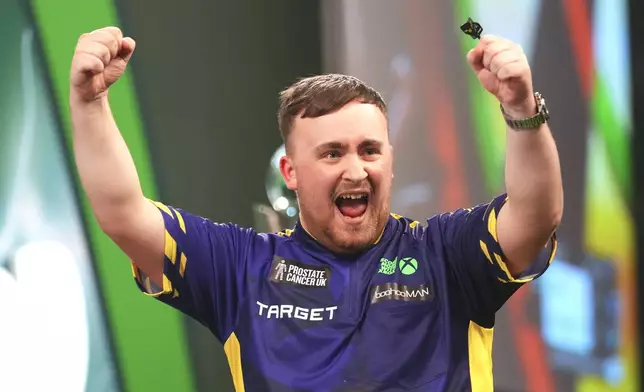 Luke Littler of England celebrates after winning the final against Michael van Gerwen of the Netherlands at the World Darts Championship at Alexandra Palace in London, Friday, Jan. 3, 2025. (AP Photo/Kirsty Wigglesworth)