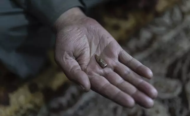 A man holds a bullet that was extracted from the abdomen of his son, who joined a protest against the Israeli military's incursion of his village, in Swisah, on the outskirts of Quneitra, Syria, Sunday, Jan. 5, 2025. (AP Photo/Mosa'ab Elshamy)