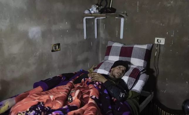 Al-Moatasem Billah Adel, 21, lies on a bed in his home after getting shot in the abdomen by the Israeli military at a protest against their incursion into his village of Swisah, on the outskirts of Quneitra, Syria, Sunday, Jan. 5, 2025. (AP Photo/Mosa'ab Elshamy)