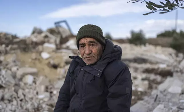 Omar Mahmoud Ismail, a local official, sits on the rubble of a home that was demolished by the Israeli military, in the village of Rafid, on the outskirts of Quneitra, Syria, Sunday, Jan. 5, 2025. (AP Photo/Mosa'ab Elshamy)