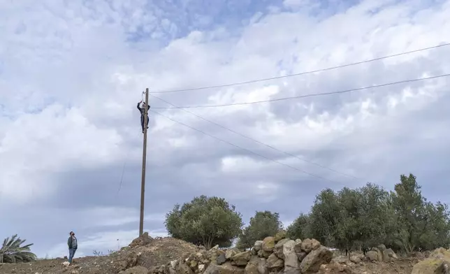 Workers fix an electricity grid in a Syrian village where the Israeli military made an incursion, in Rafid, on the outskirts of Quneitra, Syria, Sunday, Jan. 5, 2025. (AP Photo/Mosa'ab Elshamy)