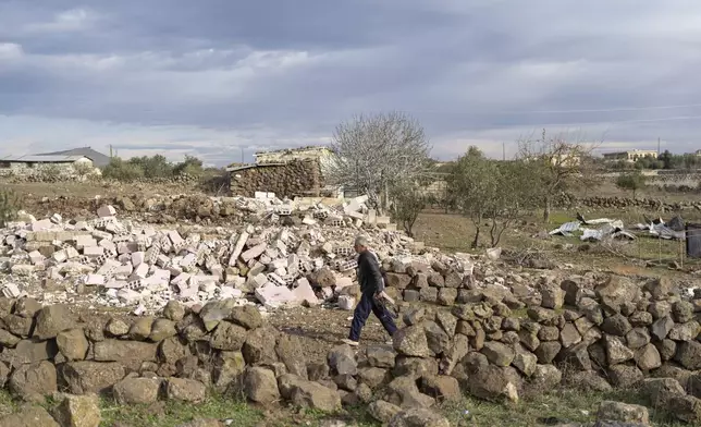 A man walks past a home that was demolished by the Israeli military, in the village of Rafid, on the outskirts of Quneitra, Syria, Sunday, Jan. 5, 2025. (AP Photo/Mosa'ab Elshamy)