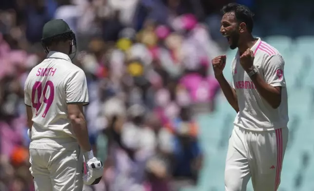 Australia's Steve Smith, left, reads after he was dismissed by India's Prasidh Krishna, right, during play on the third day of the fifth cricket test between India and Australia at the Sydney Cricket Ground, in Sydney, Australia, Sunday, Jan. 5, 2025. (AP Photo/Mark Baker)