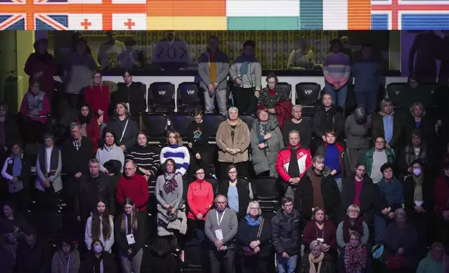 Spectators observe a moment of silence for the DC aircraft crash victims, Thursday, Jan. 30, 2025, at the ISU European Figure Skating Championships in Tallinn, Estonia. (AP Photo/Sergei Grits)