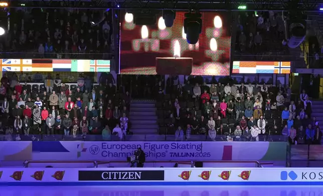 Spectators observe a moment of silence for the DC aircraft crash victims, Thursday, Jan. 30, 2025, at the ISU European Figure Skating Championships in Tallinn, Estonia. (AP Photo/Sergei Grits)