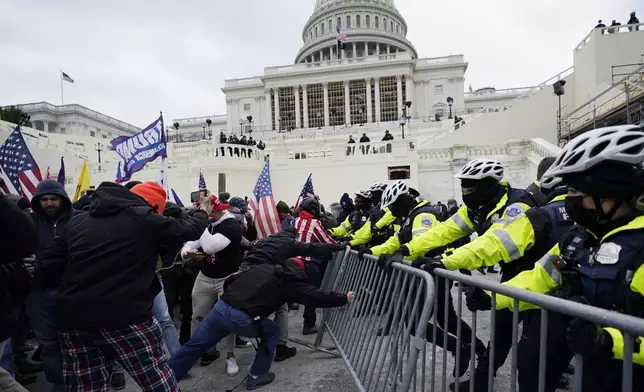 FILE - Insurrectionists loyal to President Donald Trump try to break through a police barrier, Wednesday, Jan. 6, 2021, at the Capitol in Washington. (AP Photo/Julio Cortez, File)