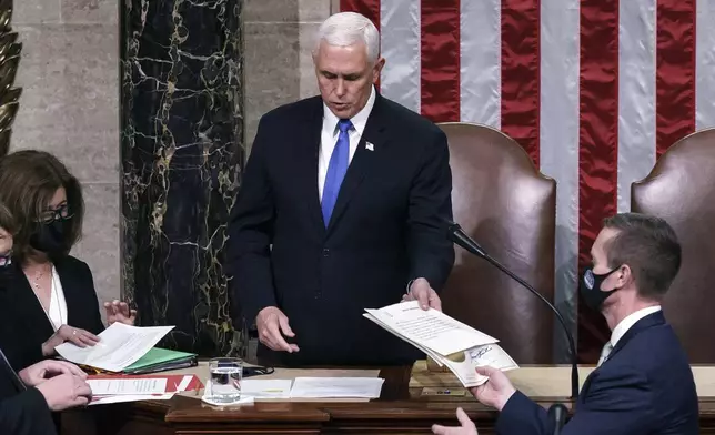 FILE - Vice President Mike Pence returns to the House chamber after midnight, Jan. 7, 2021, to finish the work of the Electoral College after a mob loyal to President Donald Trump stormed the Capitol in Washington and disrupted the process. (AP Photo/J. Scott Applewhite, File)