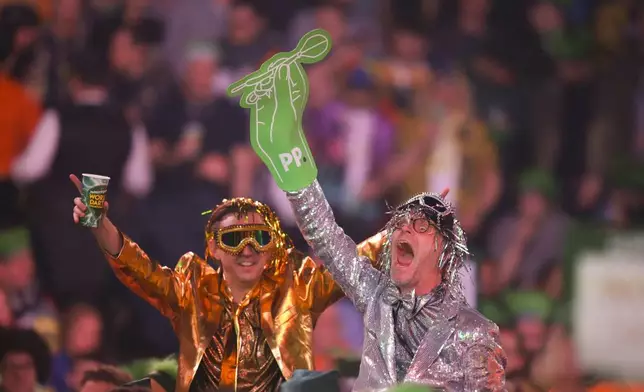 Fans cheer during the final of the World Darts Championship at Alexandra Palace in London, Friday, Jan. 3, 2025. (AP Photo/Kirsty Wigglesworth)