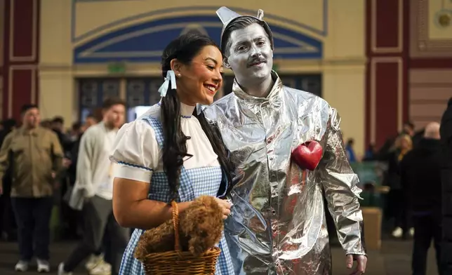 Fans dressed in costumes arrive for the start of the quarter final match between Chris Dobey of England and Gerwin Price of Wales at the World Darts Championship in London, Wednesday, Jan. 1, 2025.(AP Photo/Alberto Pezzali)