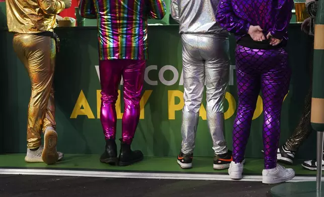 Fans in fancy dress costumes in the fan area during the round 4 match between Rob Owen of Wales and Callan Rydz of England at the World Darts Championship in London, Monday, Dec. 30, 2024. (AP Photo/Alberto Pezzali)