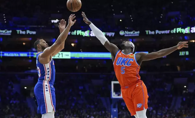 Philadelphia 76ers' Eric Gordon, left, goes up for a shot against Oklahoma City Thunder's Luguentz Dort during the first half of an NBA basketball game, Tuesday, Jan. 14, 2025, in Philadelphia. (AP Photo/Matt Slocum)